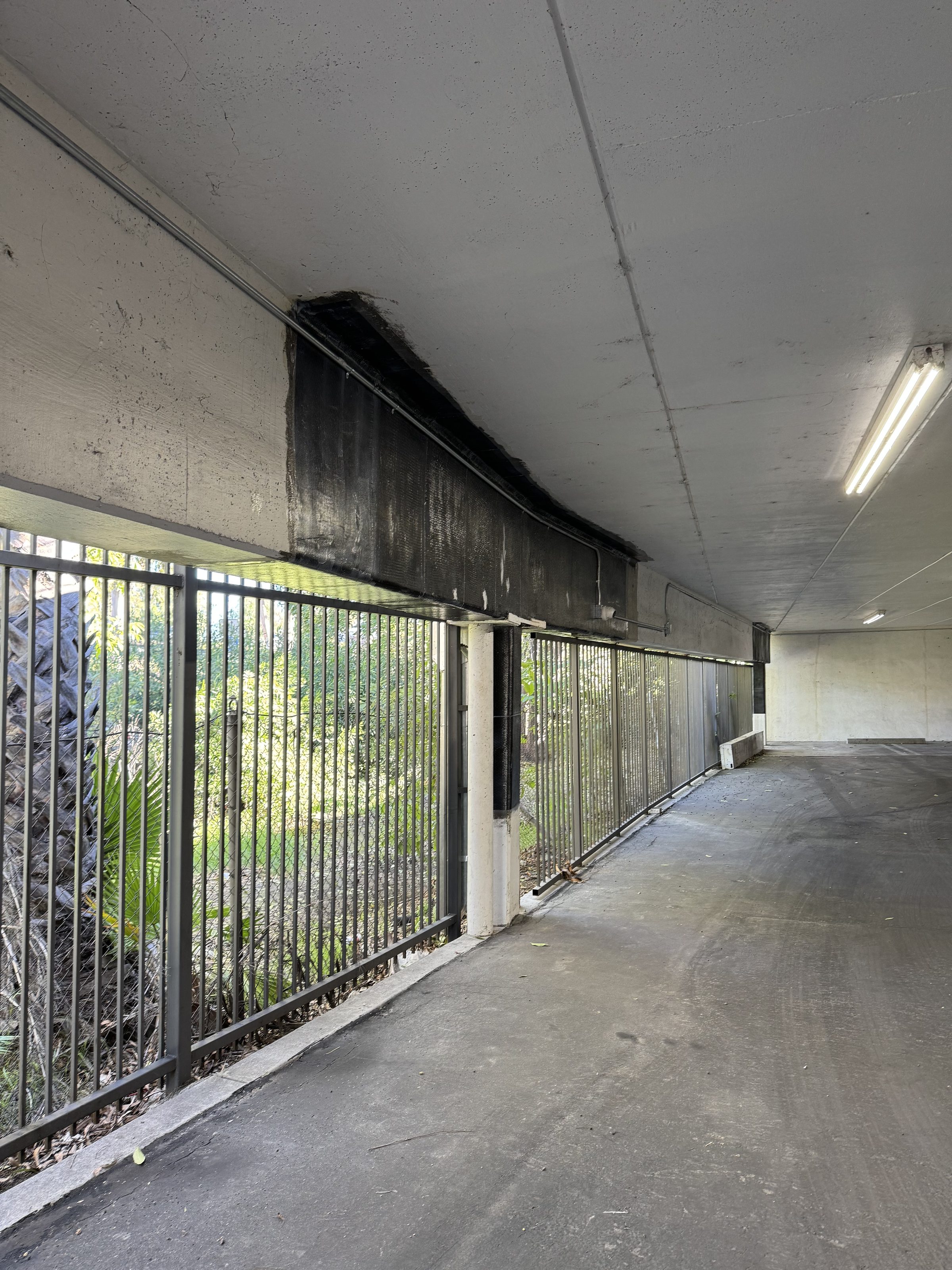 CF beam wrap — open-air parking drive aisle
