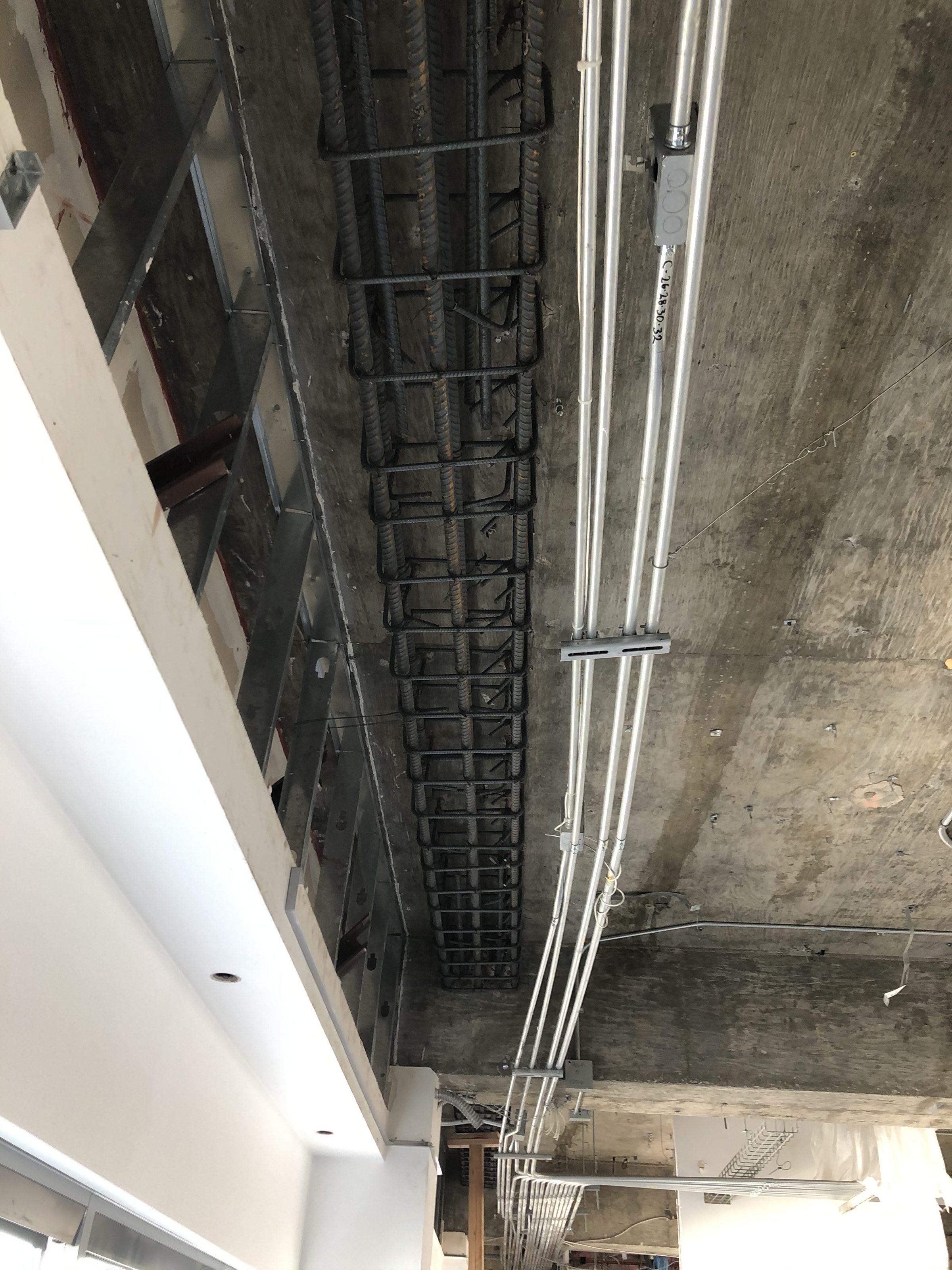Interior corridor — rebar shear wall visible through doorway