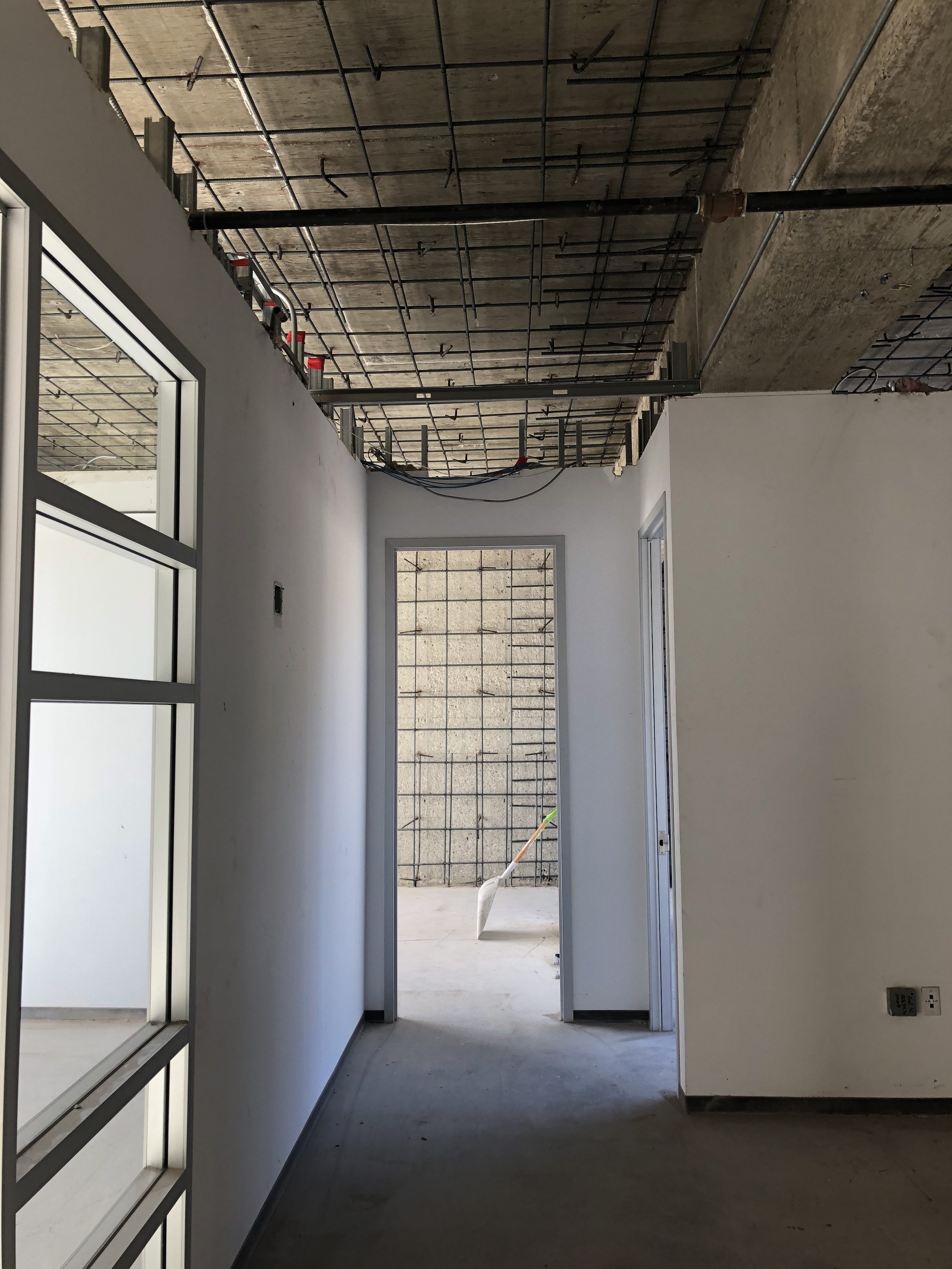 Rebar wall — corner with ceiling grid and window light