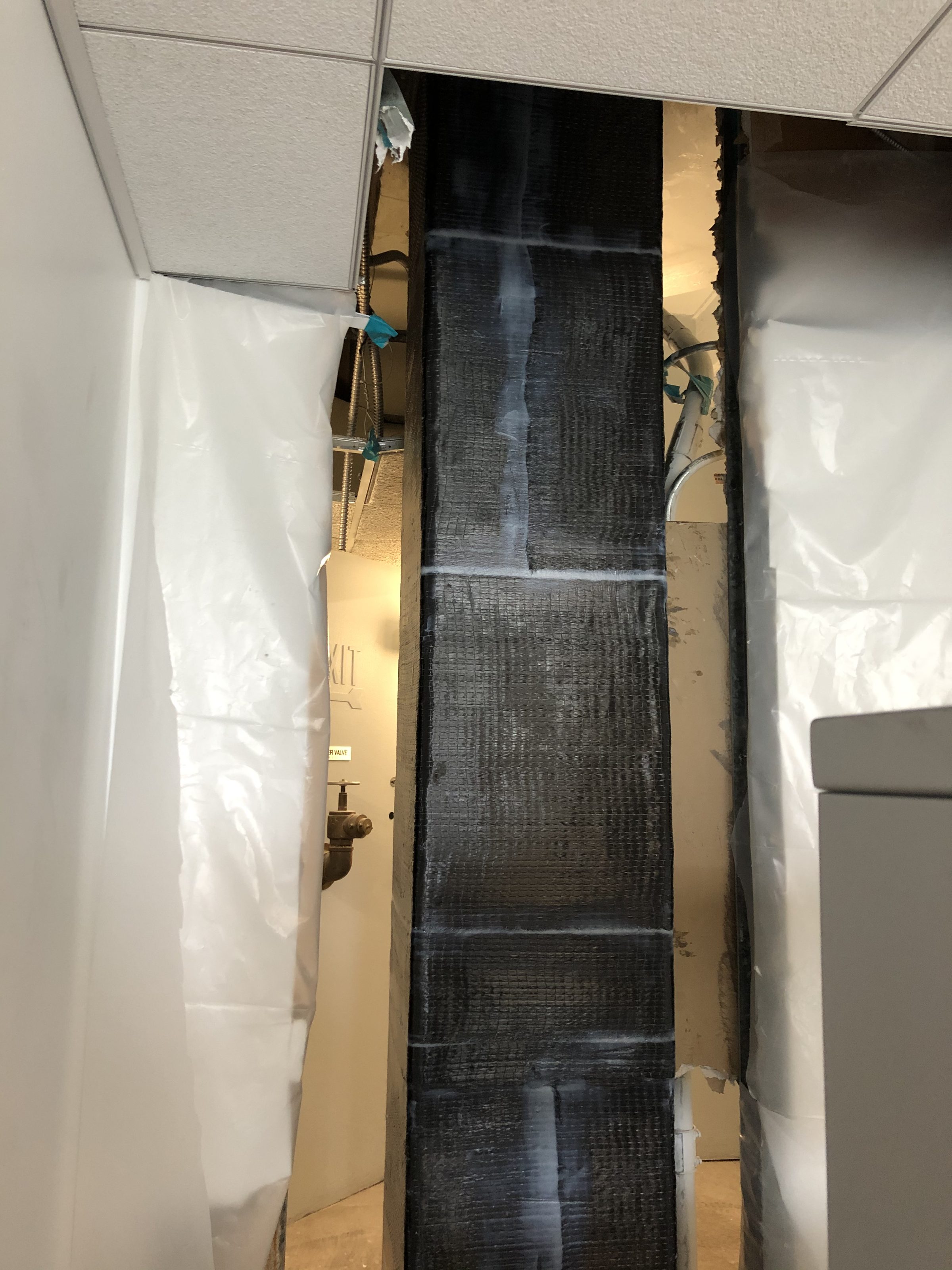 Carbon fiber beam wrap — occupied office above
