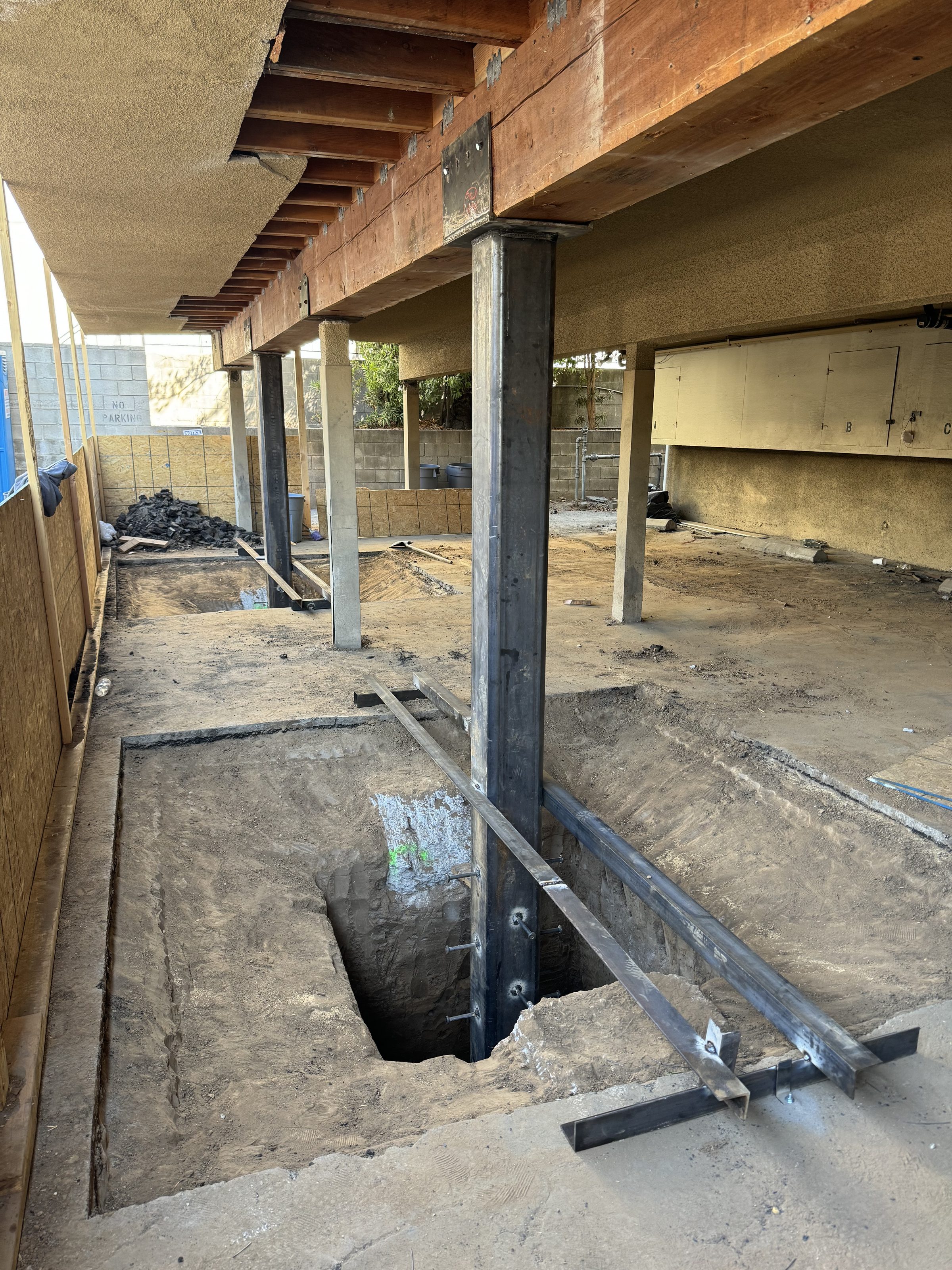 Steel columns set โ footing excavation in progress